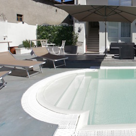 Vista piscina con lettini